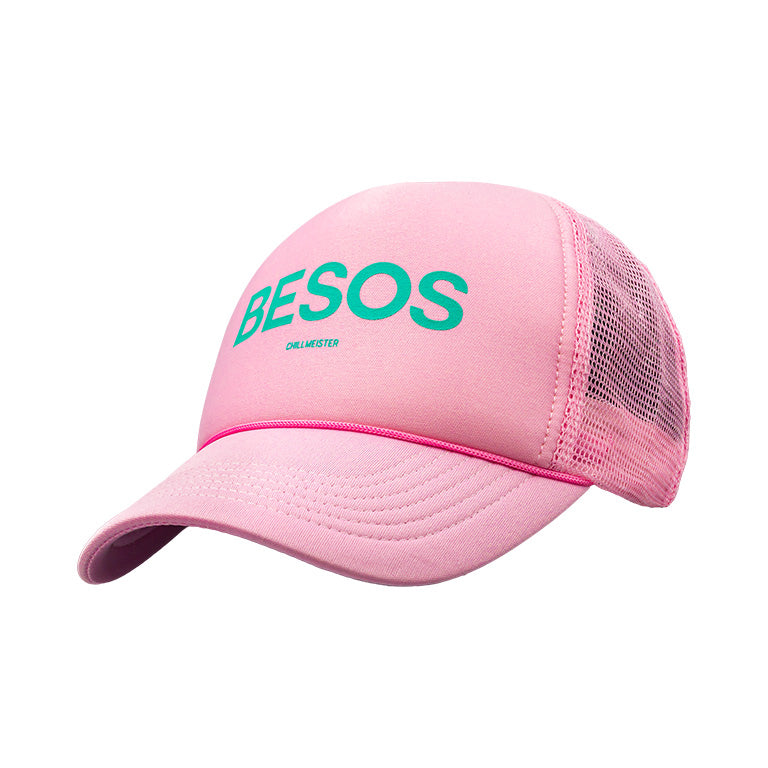 A pink trucker hat with the word 'BESOS' printed in green on the front.